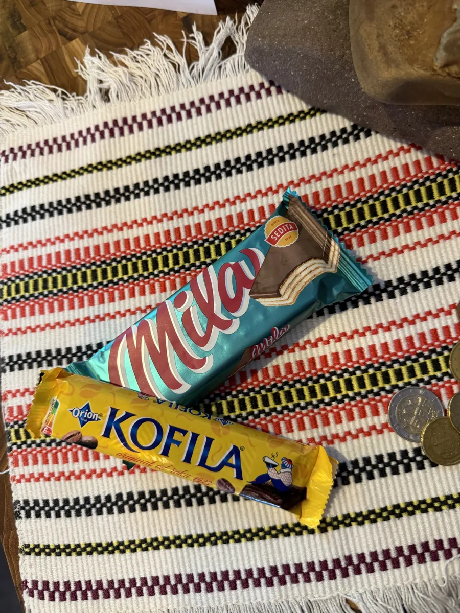 Mila and Kofila bars on a red, black and gold woven cloth